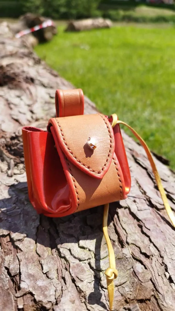 Bourse en cuir, orange vernis, lacet doré. Avec un renfort en cuir couleur naturel. Strass orange.