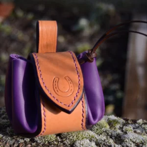Bourse en cuir violet, renforcée par une bande en cuir. Fermeture pression.
