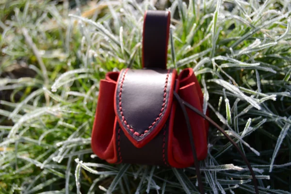 Bourse en cuir rouge, lacet marron. Avec un renfort en cuir couleur chocolat.