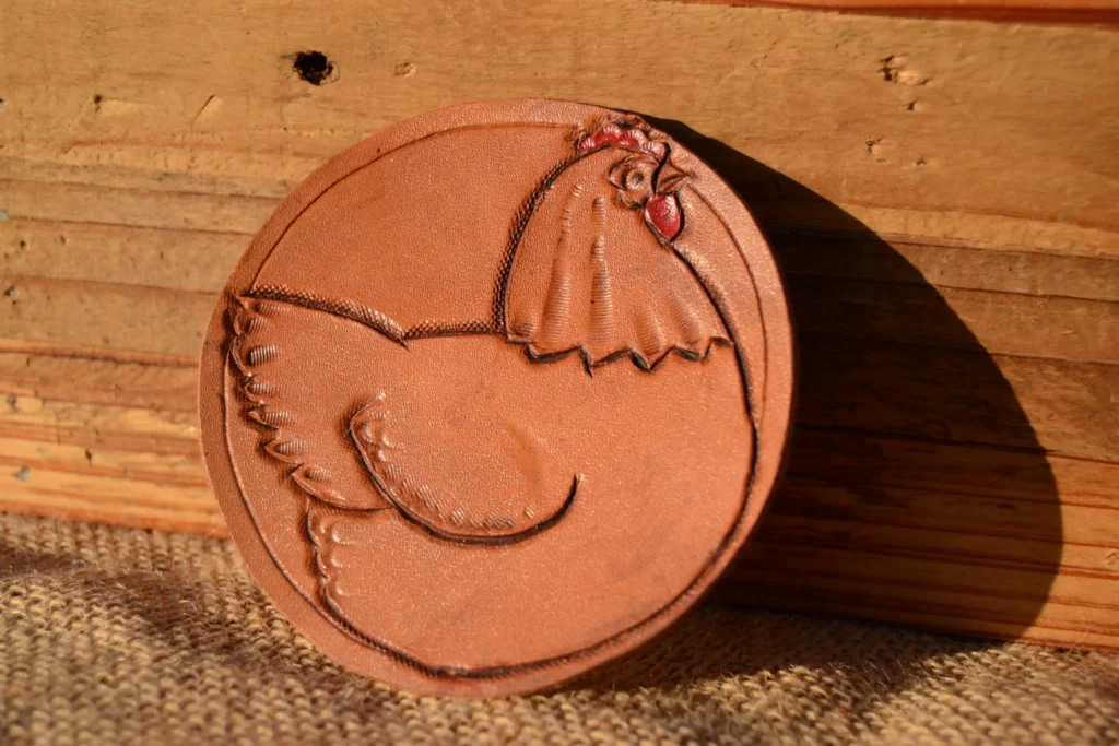 Rond de cuir avec une poule repoussé à la main